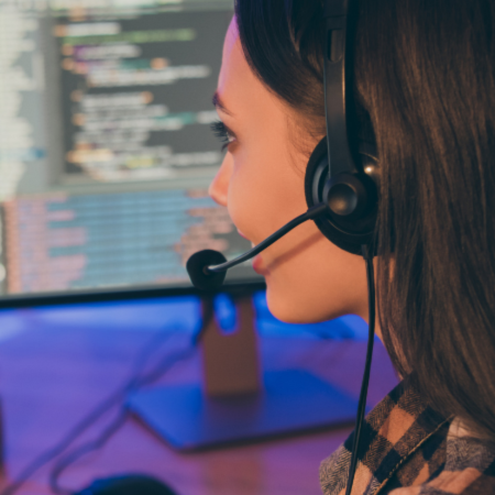 Woman wearing a headset while looking at her computer desktop